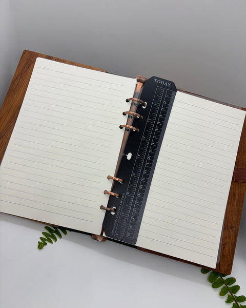 Open notebook with a wooden cover on a white surface