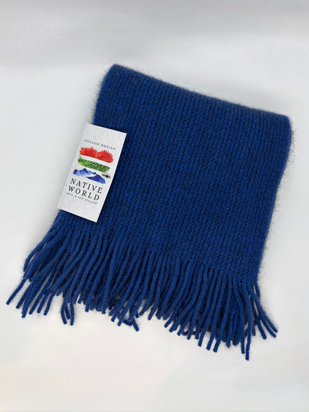 Blue scarf with fringes and a ‘Native World’ label on a white background