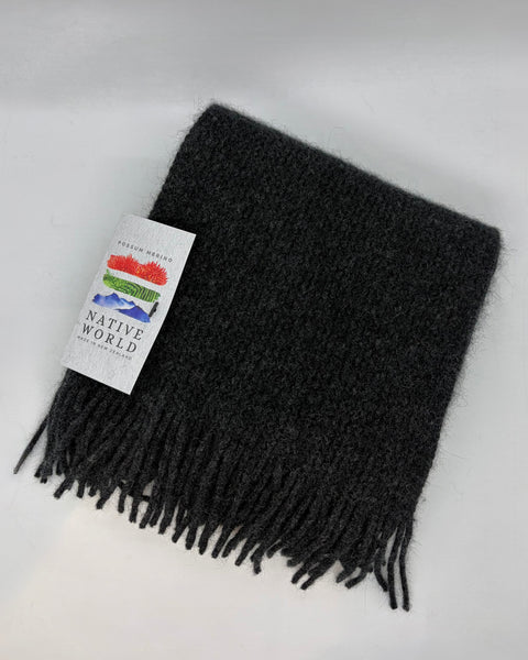 Dark grey scarf with fringe and a ‘Native World’ brand label on a white background