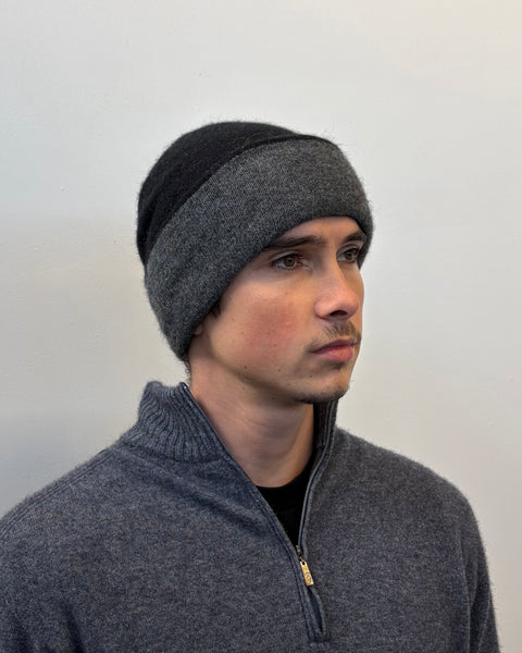 Man wearing a gray two-tone beanie against a plain background
