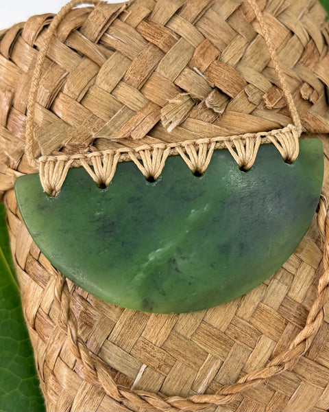 Greenstone pendant on a woven flax basket
