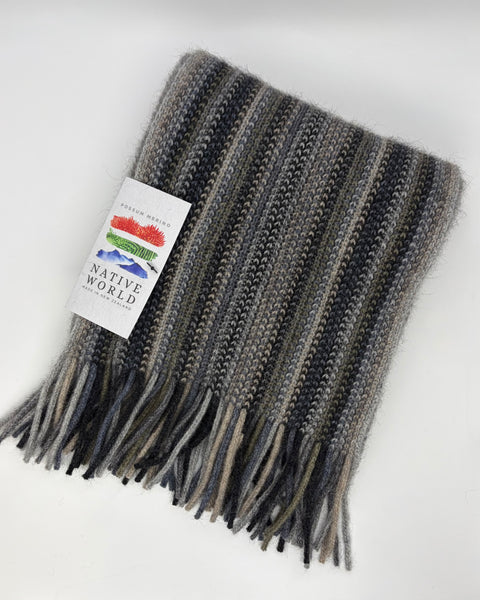 Grey knitted scarf with fringes and a label on a white background