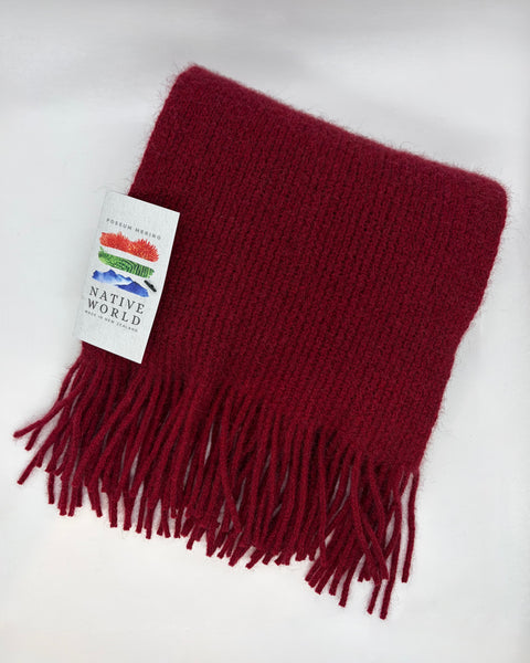 Red scarf with fringes and a 'Native World' tag on a white background