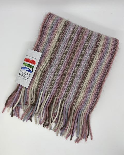 Pink knitted scarf with fringes and a ‘Native World’tag on a white background