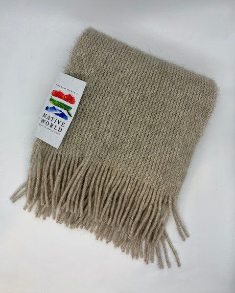 Beige knitted scarf with a ‘Native World’ brand label on a white background