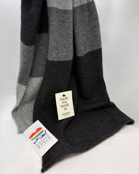 Grey and black striped knitted scarf with ‘Native World’ brand tags on a white background