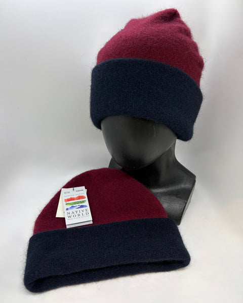 Two maroon and navy beanie hats on a mannequin head with a visible brand label against a white background.
