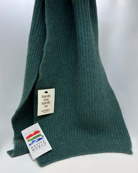 Teal knitted scarf with tags on a white background