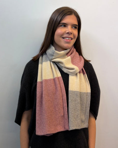 Woman wearing a striped scarf against a plain background