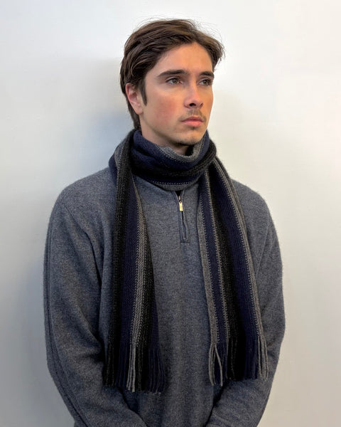 Man wearing a stripped knitted scarf against a white background