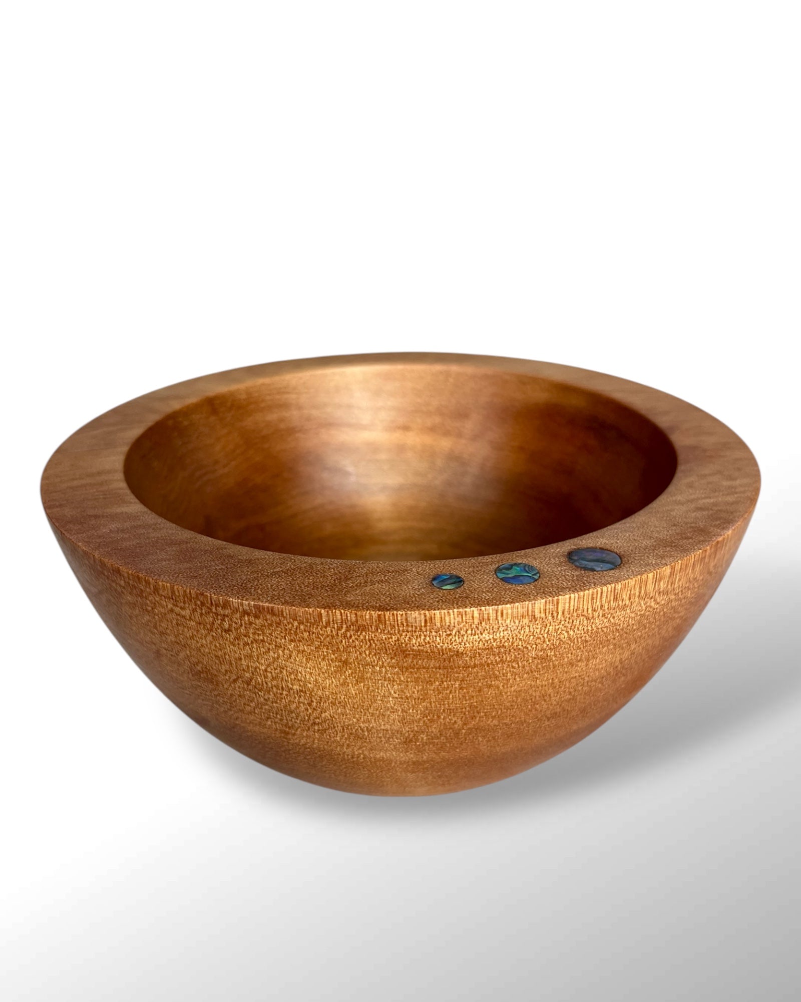 Front View of a Handcrafted NZ Native Ancient Swamp Kauri Wood Turned Bowl with three circular Paua Shell pieces inlaid in the rim.