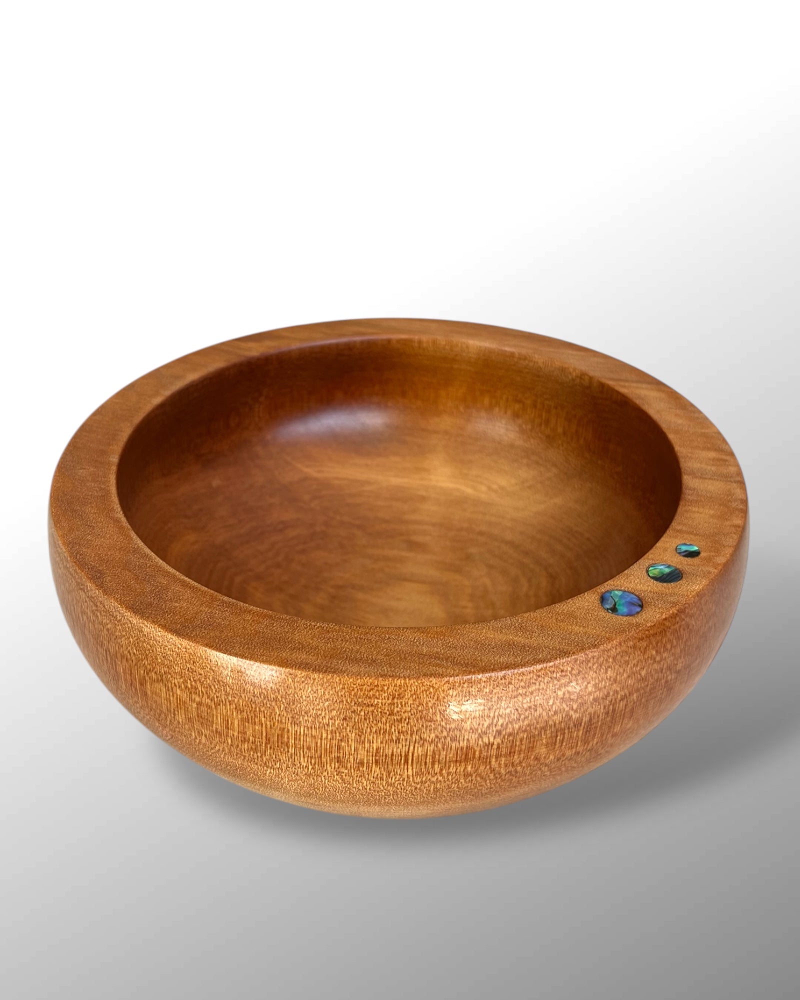 Front View of a handcrafted NZ Native Ancient Swamp Kauri Wood Turned Bowl with three circular Paua Shell pieces inlaid in the rim.