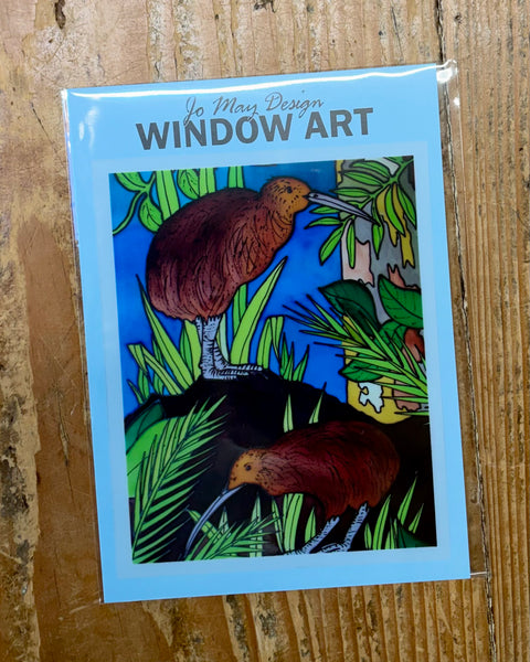 Window art design with kiwi birds on a wooden surface
