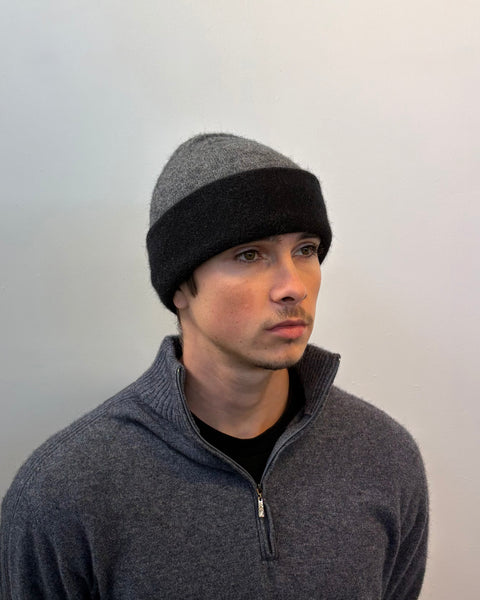 Man wearing a gray beanie and gray sweater against a plain background