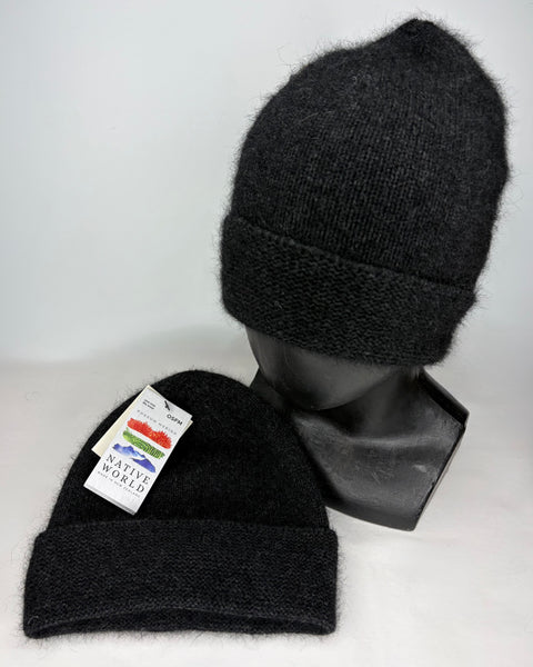 Two charcoal knit beanies on a mannequin head and a flat surface with a ‘Native World’ brand label