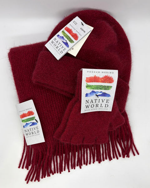 Red knit beanie, scarf and fingerless gloves set with 'Native World' tags on a white background