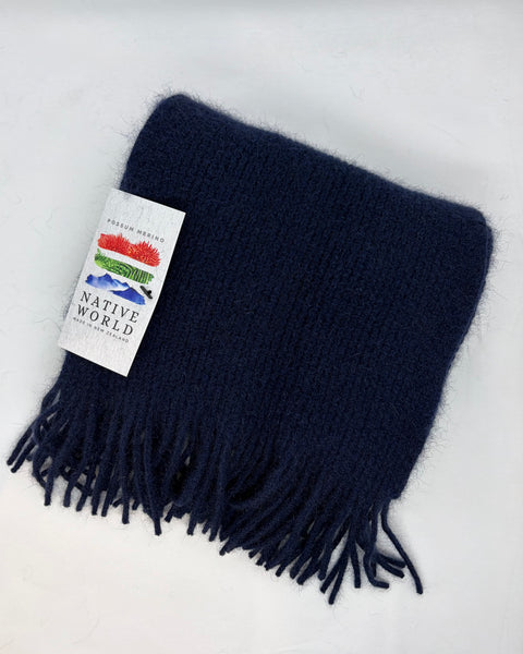 Navy blue scarf with fringes and a 'Native World' tag on a white background