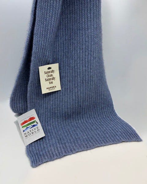 Blue knitted scarf with a tag on a white background