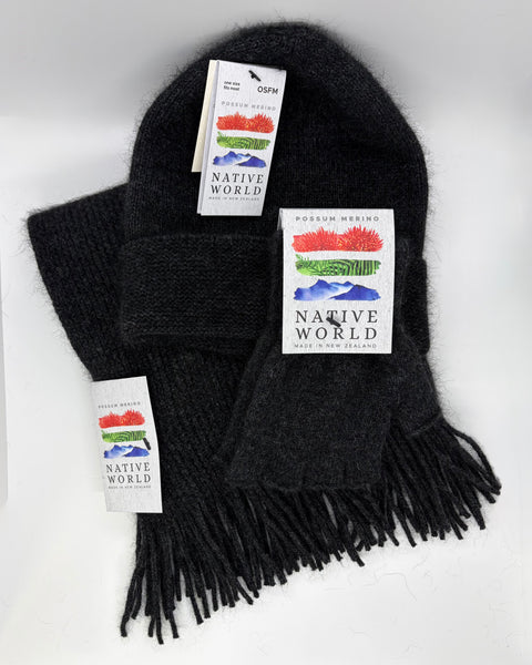 Dark grey knit beanie, scarf and fingerless gloves set with 'Native World' tags on a white background