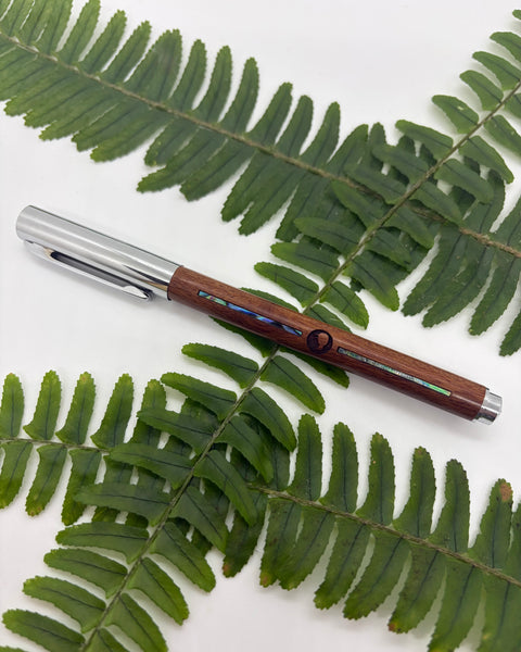 Wooden pen with silver cap and paua shell accents.