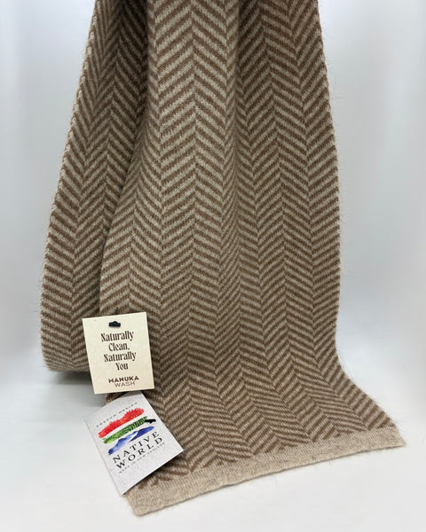 Brown herringbone patterned scarf with two labels on a white background