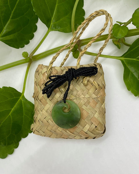 Greenstone disc pendant with spiral koru and black woven neck cord