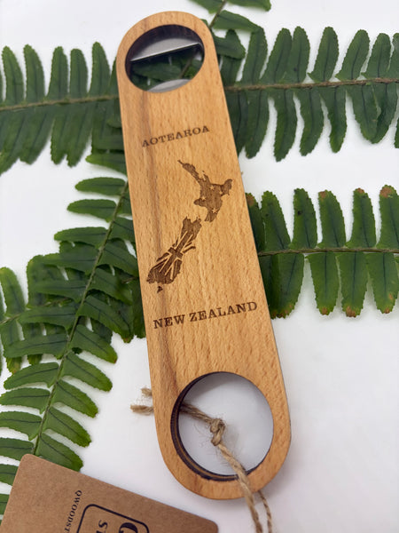Wooden bottle opener with 'Aotearoa New Zealand' engraving on green leaves