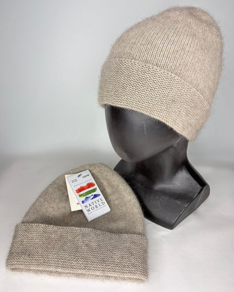 Two beige knit beanies on a mannequin head and a flat surface with a ‘Native World’ tag
