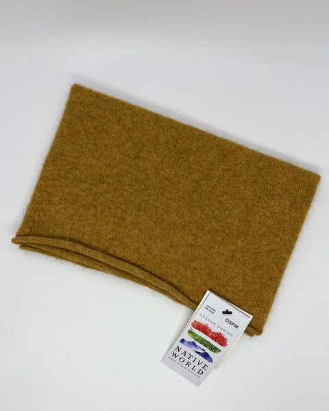 Folded mustard yellow neck warmer with Native World tag on a white background