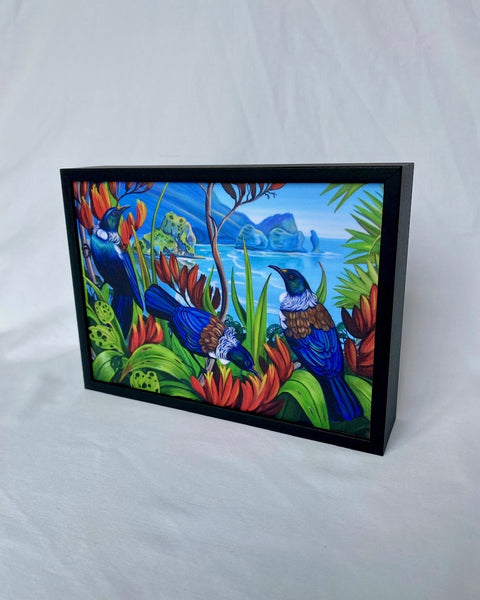 Framed artwork of Tui birds in a tropical setting on a white background