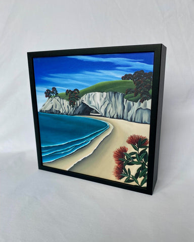 Framed artwork of a coastal scene with flowers on a white background