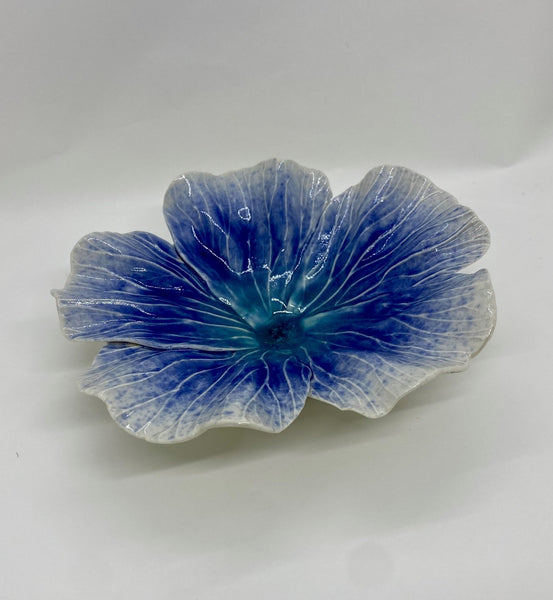 Blue ceramic flower-shaped dish on a white background