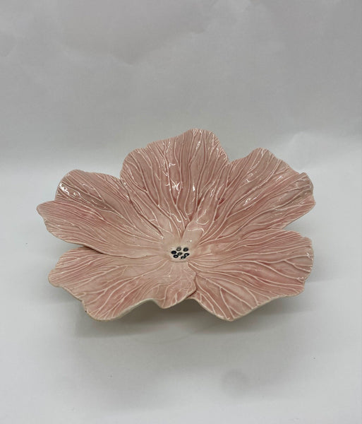 Pink ceramic flower-shaped dish on a white background