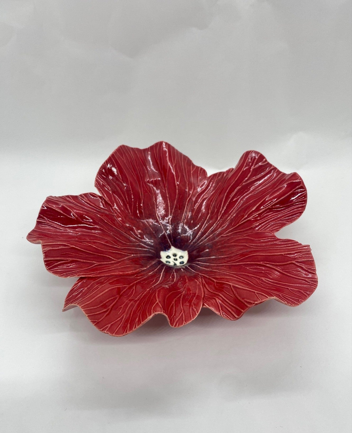 Red ceramic flower dish on a white background
