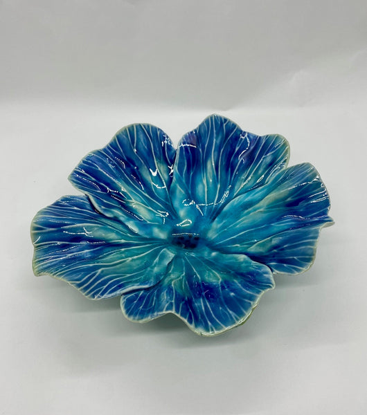 Blue ceramic flower-shaped dish on a white background