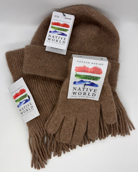 Brown knitted beanie, scarf and gloves set with 'Native World' tags against a white a background.
