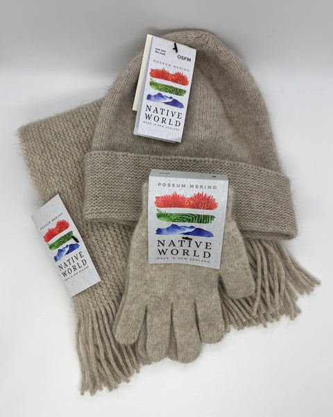 Beige knit beanie, scarf and gloves set with 'Native World' tags against a white background.