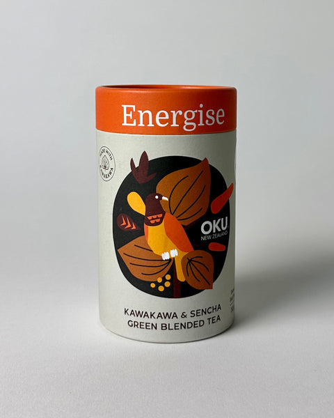 A package of OKU Energise tea bags with a black label featuring a bird and leaves design, and text indicating the blend of Kawakawa and Sencha green tea.