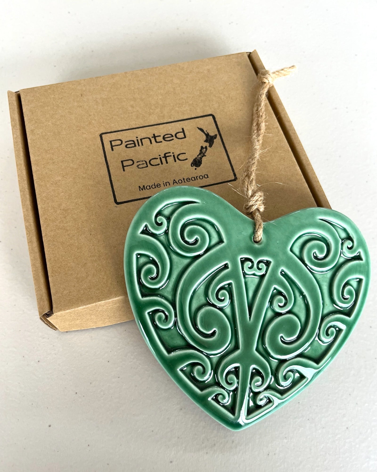 Ceramic Green Heart decoration in a gift box with Maori Kowhaiwhai design and twine loop for hanging. Made in Aotearoa New Zealand by Painted Pacific Pottery.