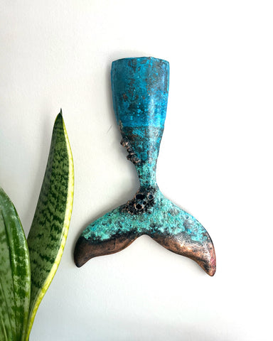 Decorative copper whale tail with a textured blue patina and bronze finish.