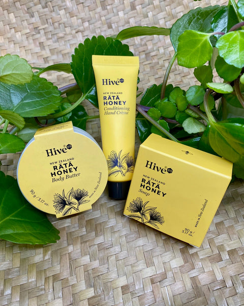 Hive New Zealand Rata Honey skincare products on a woven surface with green leaves.