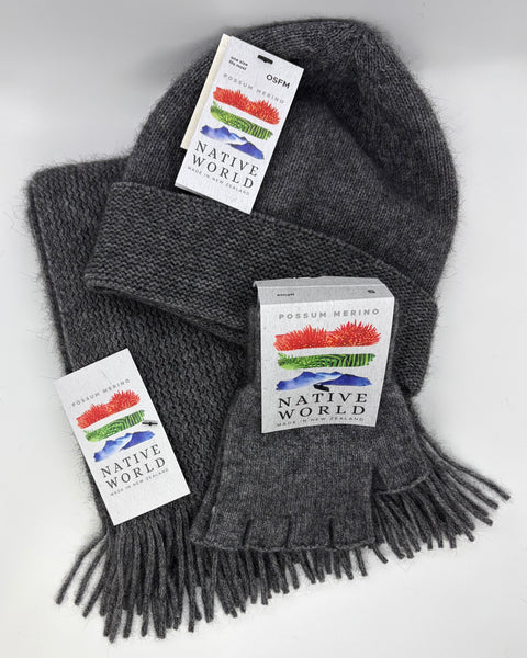 Grey knit beanie, scarf and fingerless gloves set with 'Native World' tags on a white background