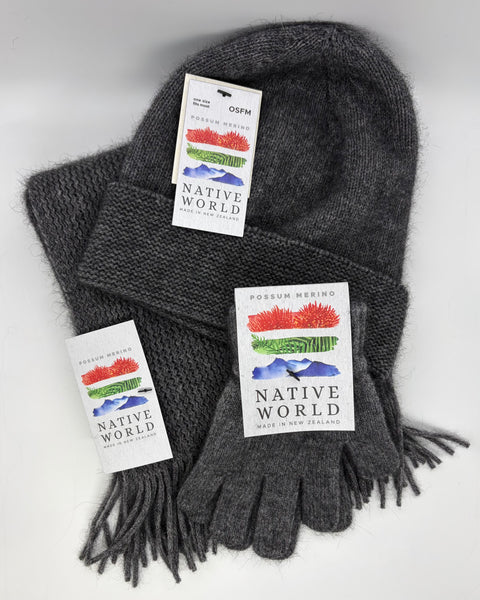 Grey knit beanie, scarf and gloves set with 'Native World' tags against a white background