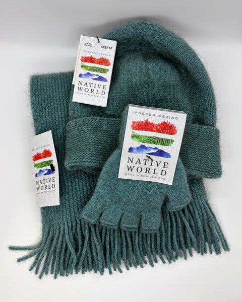 Teal knitted Beanie, scarf and fingerless gloves set with 'Native World' tags on a white background