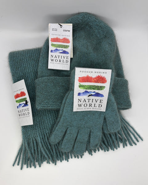 Teal knit scarf, beanie and gloves set with 'Native World' tags against a white background