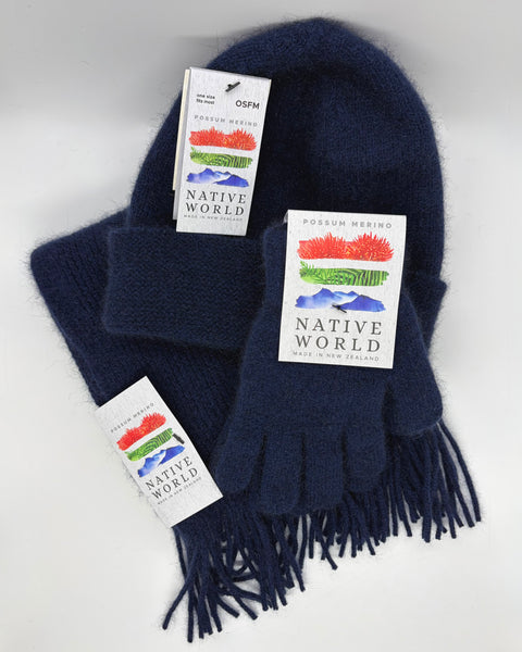 Navy blue knitted scarf, beanie and gloves set with 'Native World' tags against a white background.