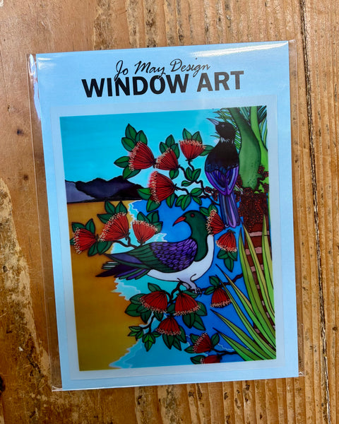 Window art decal with birds and red flowers on a wooden surface