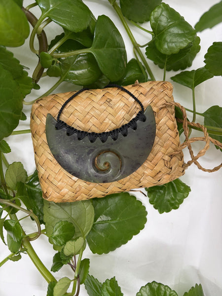 Greenstone breastplate necklace on a woven flax bag