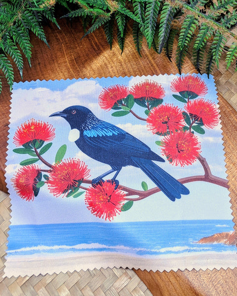 A lens screen cleaning cloth featuring the NZ Tui by the seashore, amongst the Pohutakawa flowers.

Cloth dimensions: 14.5cm x 14cm