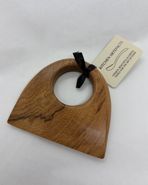 Wooden food chopper with a cream product tag.